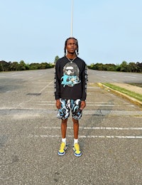 a man in a black long sleeve shirt standing in a parking lot